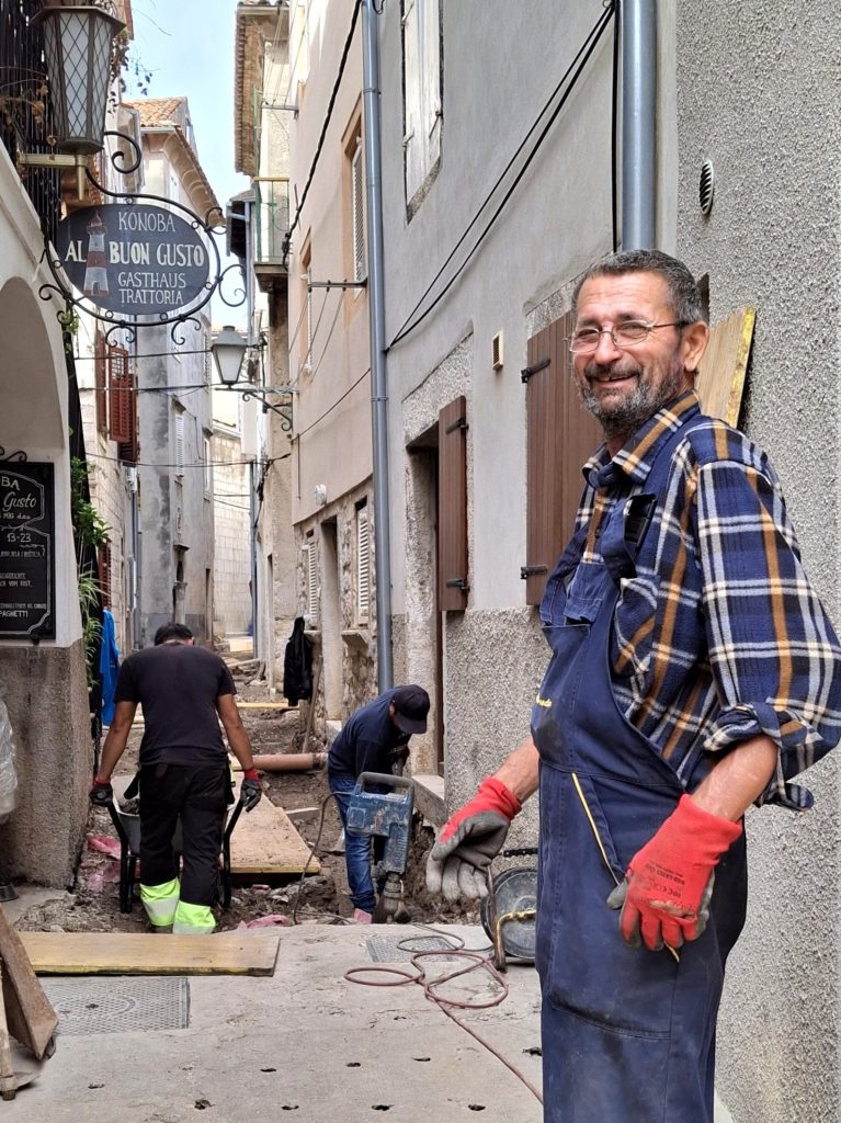 Worker in a narrow street on Cres