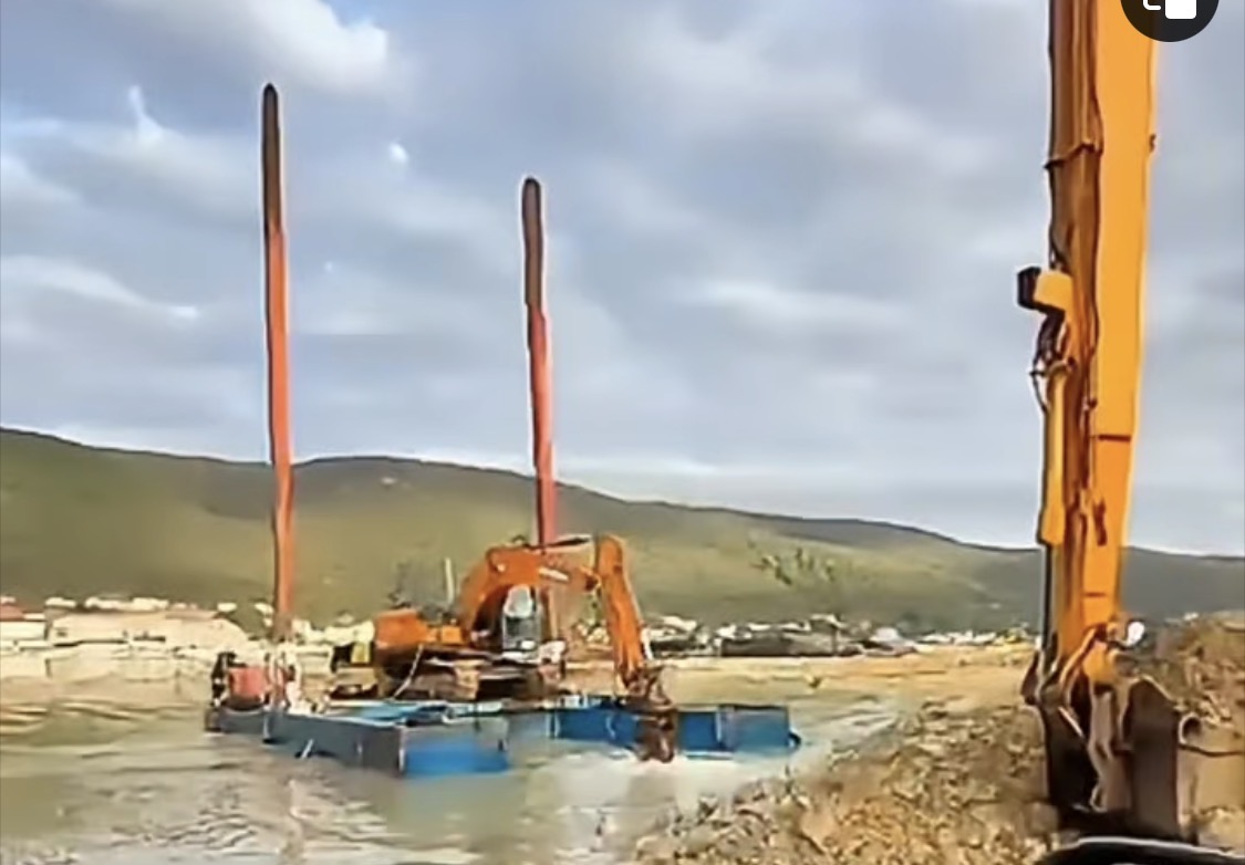 Excavator on a floating platform at sea